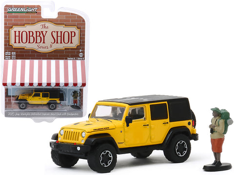 2015 Jeep Wrangler Unlimited Rubicon Hard Rock Yellow with Black Top and Backpacker Figurine \"The Hobby Shop\" Series 8 1/64 Diecast Model Car by Greenlight